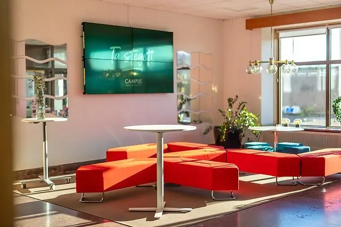 Bild på röda soffor, vit bord i receptionen på Campus västra Skaraborg