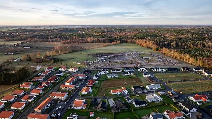 Drönarvy över ett bostadsområde och skog.